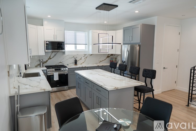 A modern kitchen with a marble island and stainless steel appliances.