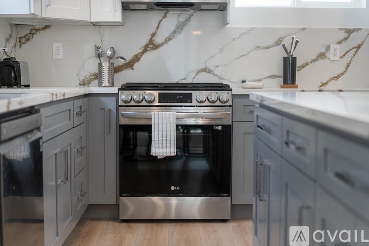 A modern kitchen with a stainless steel oven and marble countertops.