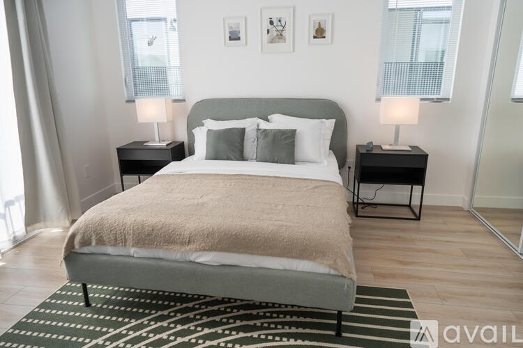 A bedroom with a large bed and two lamps.