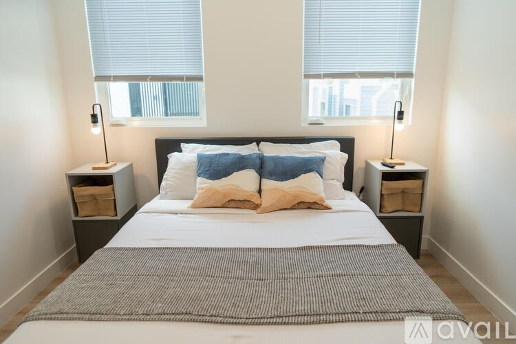 A bedroom with a large bed and two nightstands with lamps.