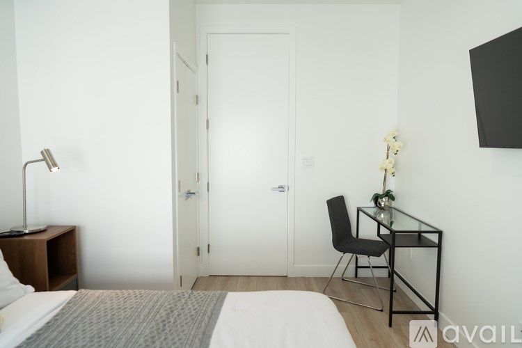 A bedroom with a bed, desk, and chair.