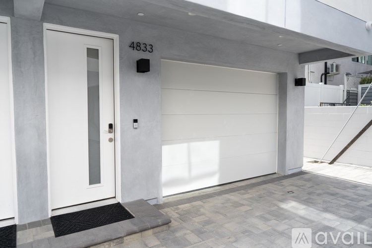A modern house entrance with a white door and a black mat.