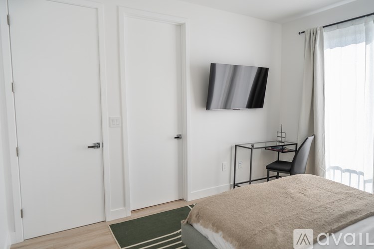 A bedroom with a bed, a chair, and a painting on the wall.