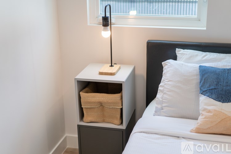 A bedroom with a bed, nightstand, and lamp.