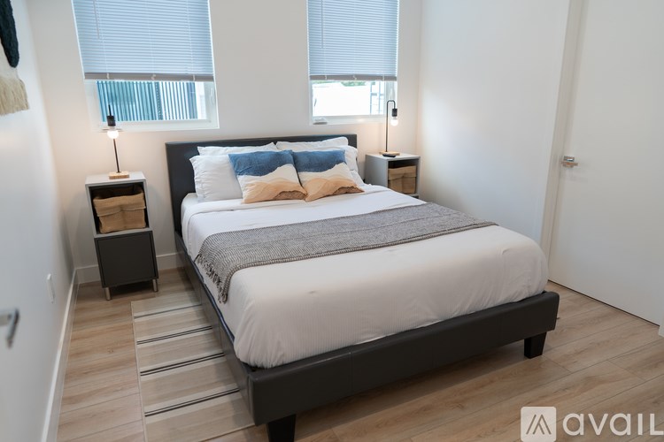 A bedroom with a large bed and a wooden floor.