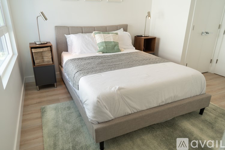 A bedroom with a large bed and a green rug.