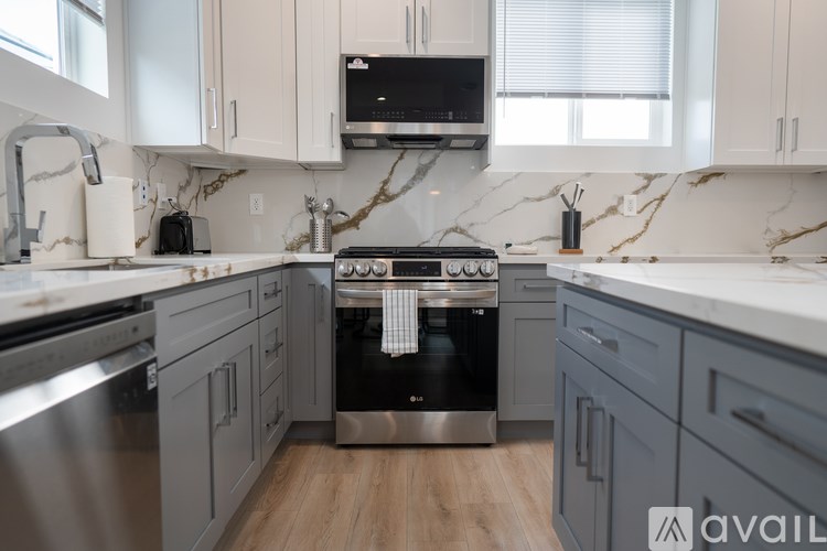 A kitchen with a marble countertop and a stainless steel oven.