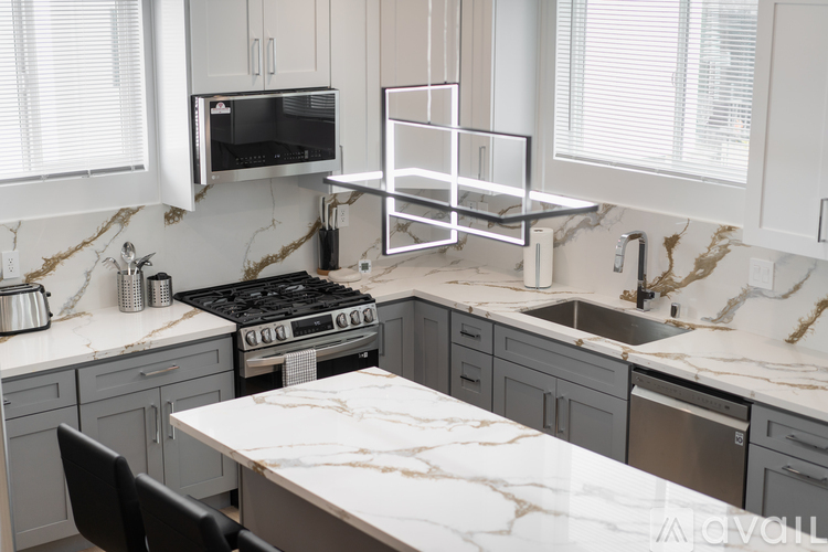 A kitchen with a marble countertop and a stove top oven.