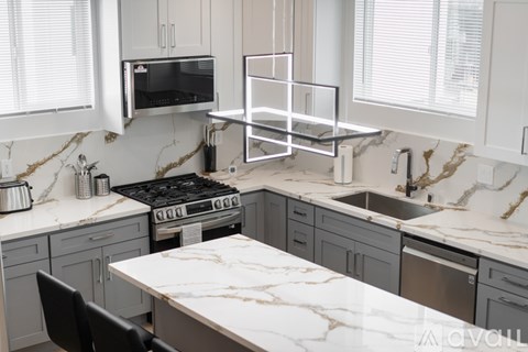 A kitchen with a marble countertop and a stove top oven.