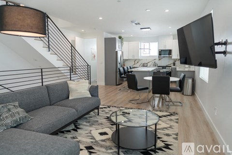 A living room with a grey sofa and a black and white rug.