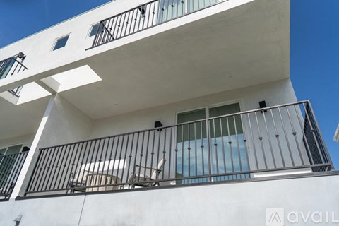 A white building with black railings and windows.