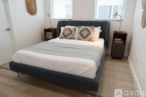 A bedroom with a large bed and two lamps on either side.