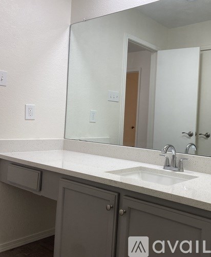 A bathroom with a sink and a mirror.