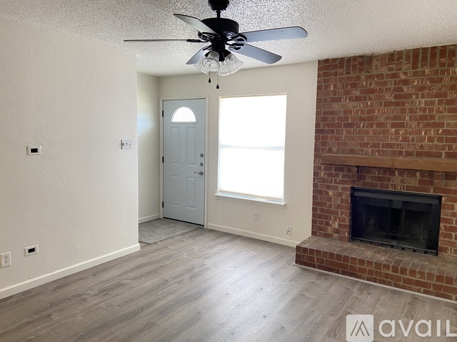 A room with a fireplace and a ceiling fan.