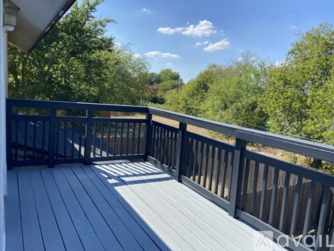 A deck with a railing and trees in the background.