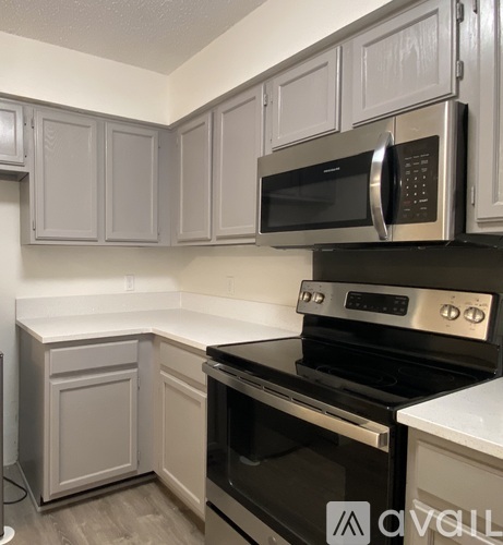A kitchen with a black stove top oven and a black microwave above it.