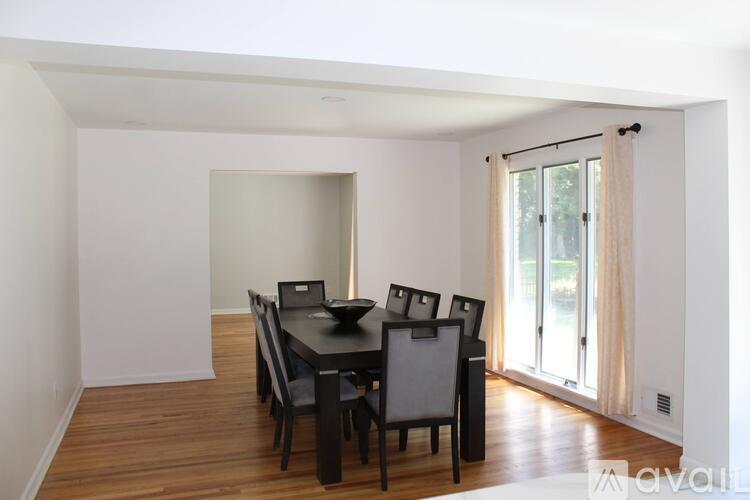 A dining room with a table and chairs.