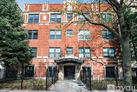 A red brick building with a black gate in front.