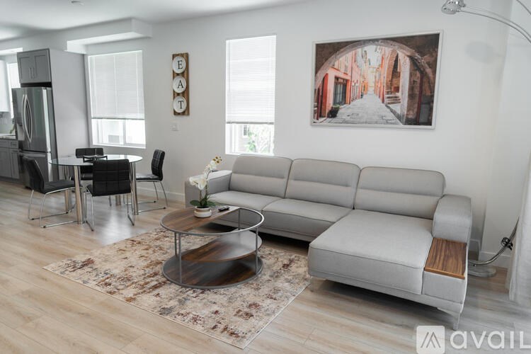 A living room with a grey sofa, a black chair, and a coffee table.