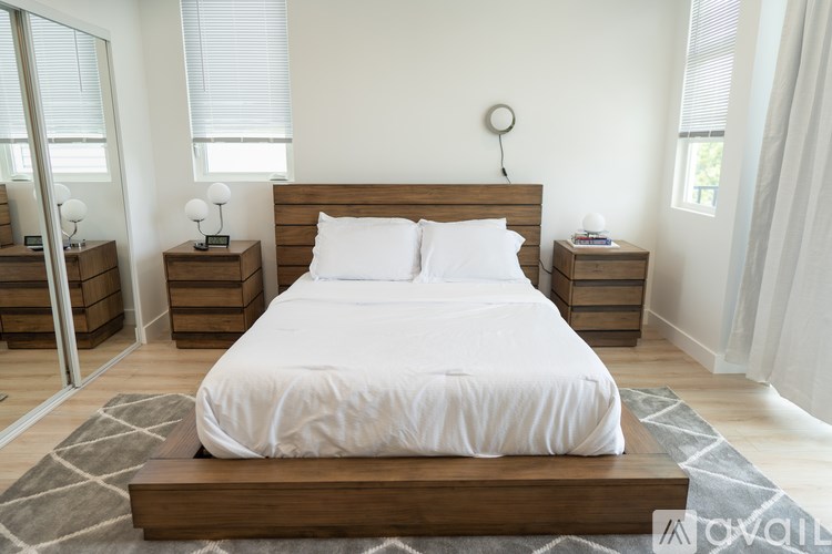 A bedroom with a large bed, nightstands, and a mirror.