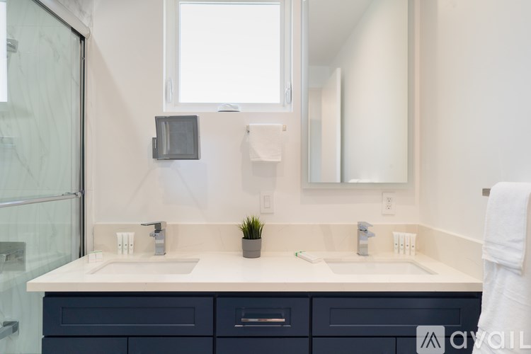 A modern bathroom with two sinks and a large mirror.
