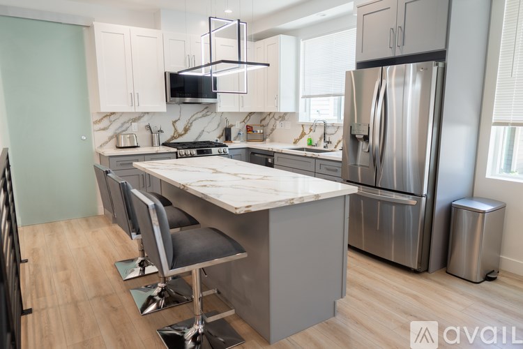 A kitchen with a marble countertop and stainless steel appliances.