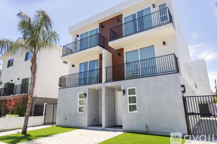A modern two-story building with balconies and doors.