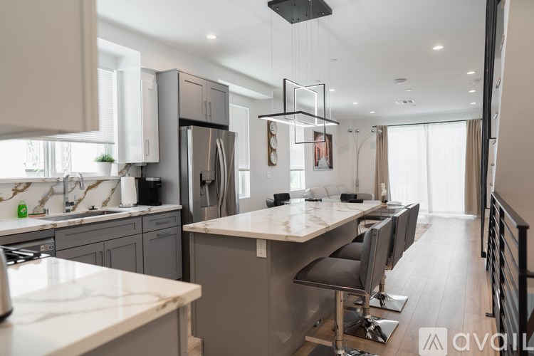 A modern kitchen with a marble countertop and stainless steel appliances.