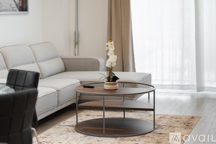 A modern living room with a glass coffee table and a white sofa.