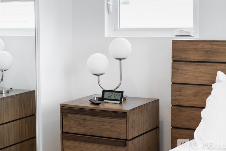 A bedroom with a bed, nightstand, and lamp.