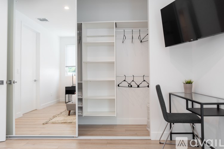 A modern room with a glass table and a black chair.