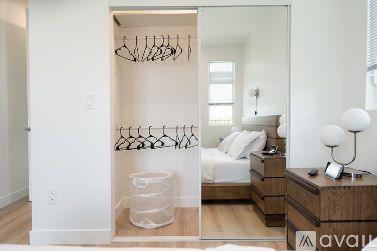 A bedroom with a bed, nightstand, and a closet with a white interior.