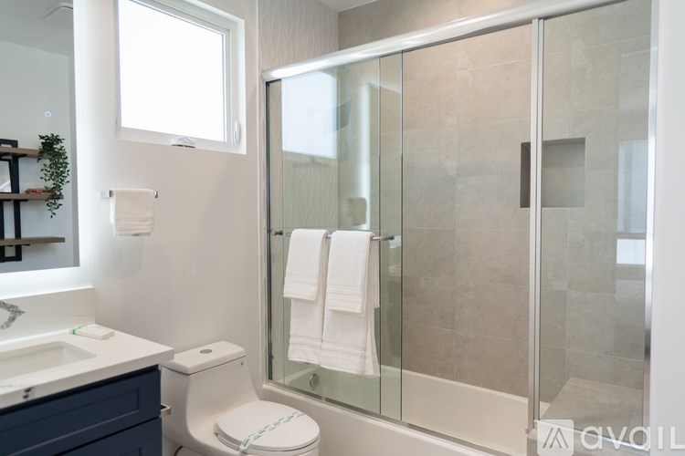 A bathroom with a toilet, sink, and shower.