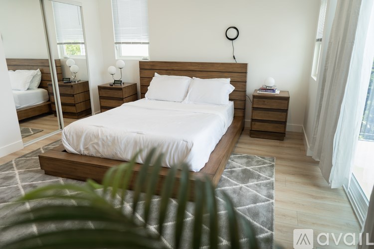 A bedroom with a large bed and a mirror on the wall.