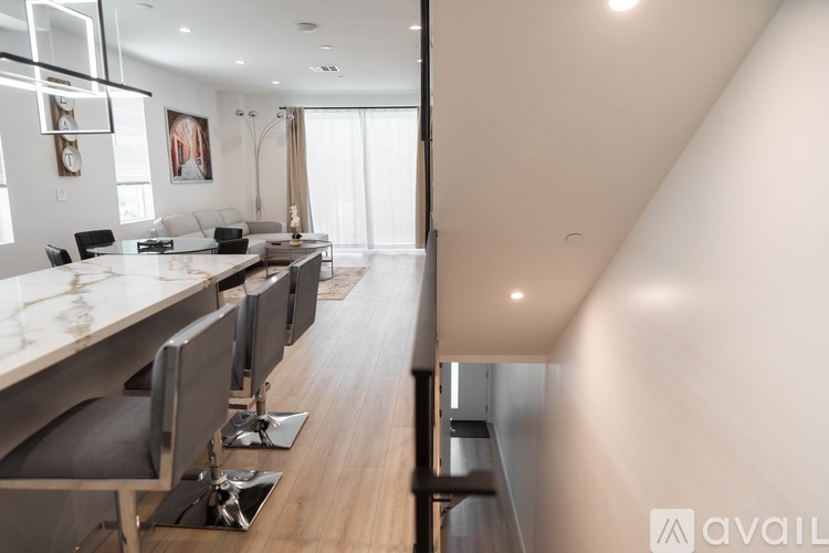 A modern kitchen with a long island and chairs.