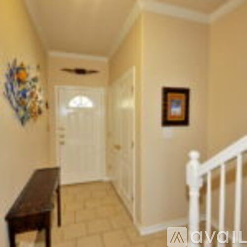 A hallway with a white railing and a painting on the wall.