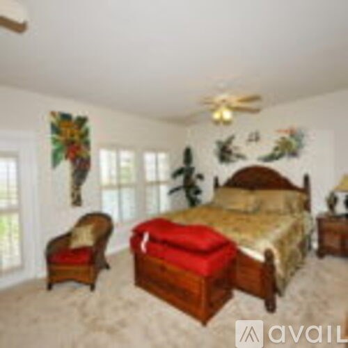A bedroom with a bed, chair, and wall art.