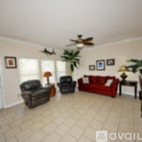 A living room with a red couch and a ceiling fan.