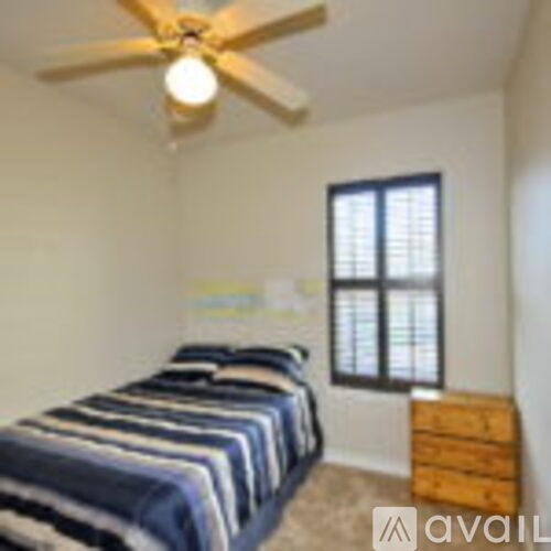 A bedroom with a bed, dresser, and window.