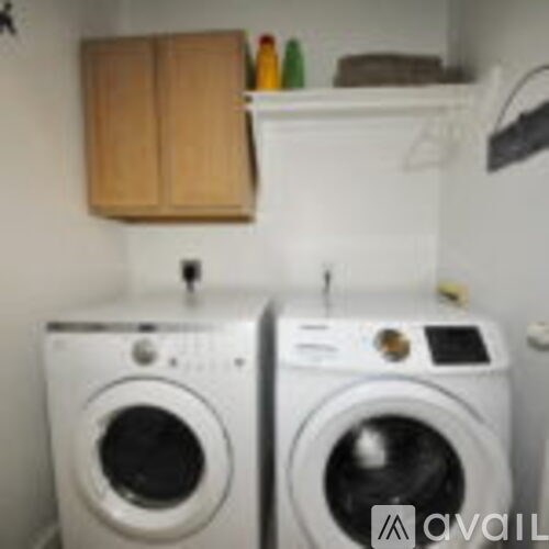 Two front loading washing machines in a small laundry room.