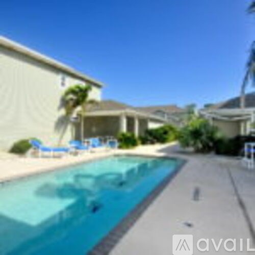 A pool in a backyard with a house in the background.