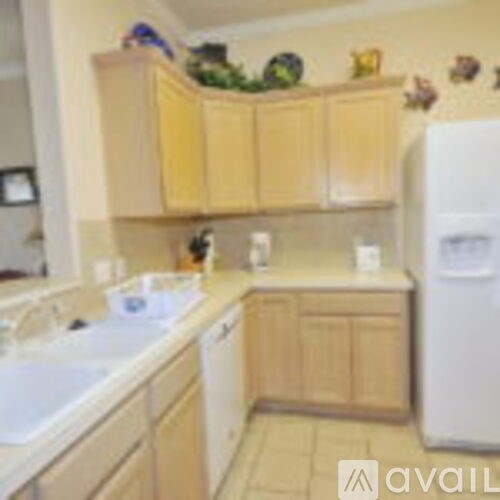 A kitchen with wooden cabinets and a white fridge.