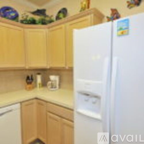 A kitchen with wooden cabinets and a white refrigerator.