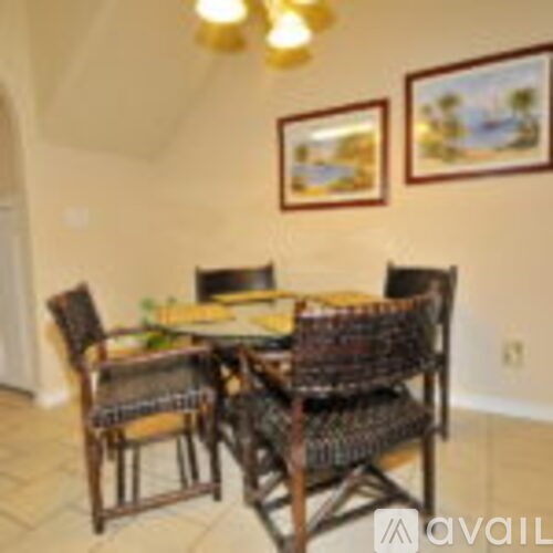 A dining room with a table and chairs.