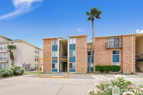 A building with a blue door and windows is surrounded by palm trees.