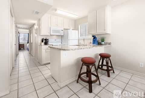 A kitchen with white cabinets and a white fridge.