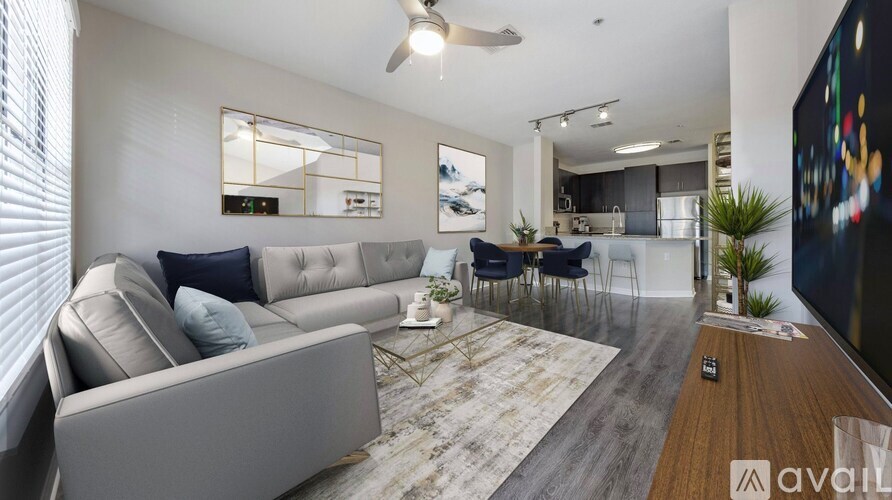 A modern living room with a grey sofa, a coffee table, and a television.