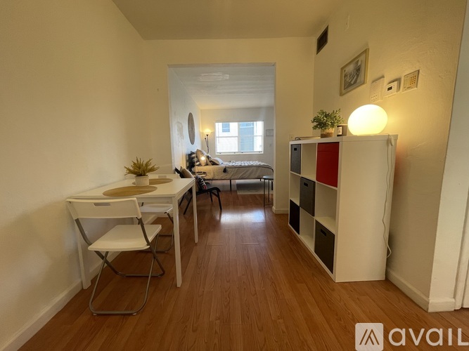 A room with a desk, chair, and a bed.