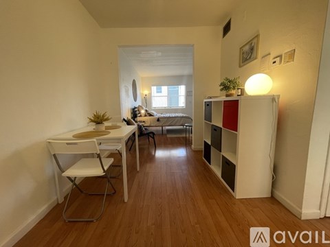 A room with a desk, chair, and a bed.