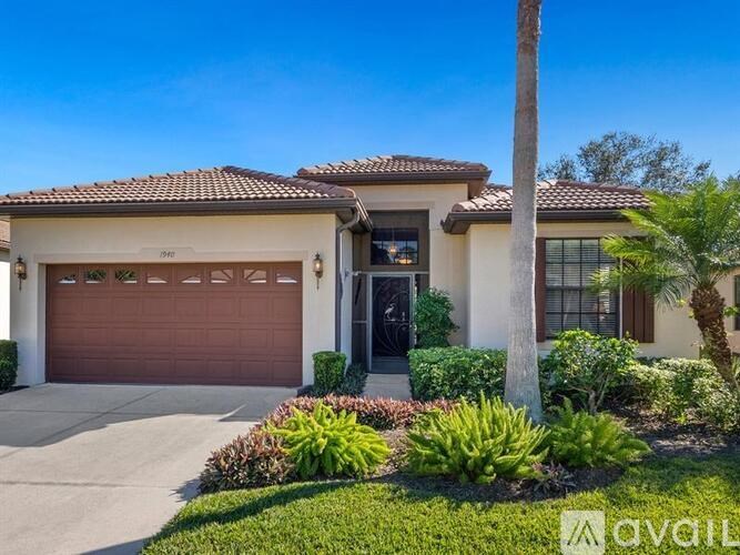A house with a brown garage door and a palm tree in front.